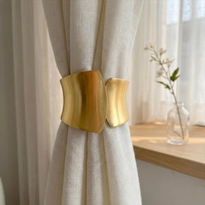 May include: A set of three ceramic mugs with a speckled, matte finish. The mugs are in shades of cream, light gray, and dark gray. Each mug has a simple, minimalist design and a rounded handle.