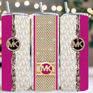 Könnte beinhalten: Drei Edelstahlbecher mit Strohhalmen. Die Becher weisen ein sich wiederholendes Muster von "MK"-Logos in Hellbeige auf. Eine Seite hat eine fuchsiafarbene Tafel mit einer goldenen Kette und einem "MK"-Logo-Anhänger. Der mittlere Becher hat ein goldenes Mesh-Design.