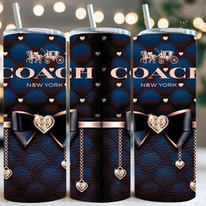 Peut inclure: Trois gobelets en acier inoxydable avec couvercles et pailles. Les gobelets présentent un motif matelassé bleu marine avec le logo Coach New York, un nœud avec un ornement en forme de cœur et des breloques en forme de cœur. Le design comprend une calèche.