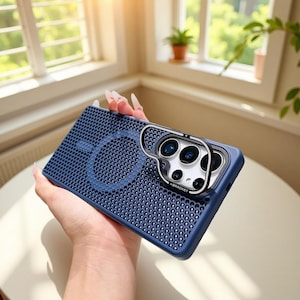 May include: A navy blue phone case with a textured, dotted pattern and a silver camera lens protector. The case has a circular design on the back and a bracket around the camera lenses.