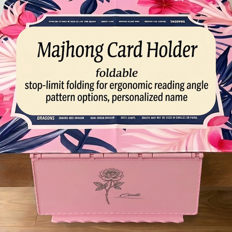 May include: A light pink foldable Majhong card holder featuring a rose illustration and the name Cindi engraved on the front. The product includes a display card with the text Majhong Card Holder, foldable, stop-limit folding for ergonomic reading angle, pattern options, personalised name, and game terminology.