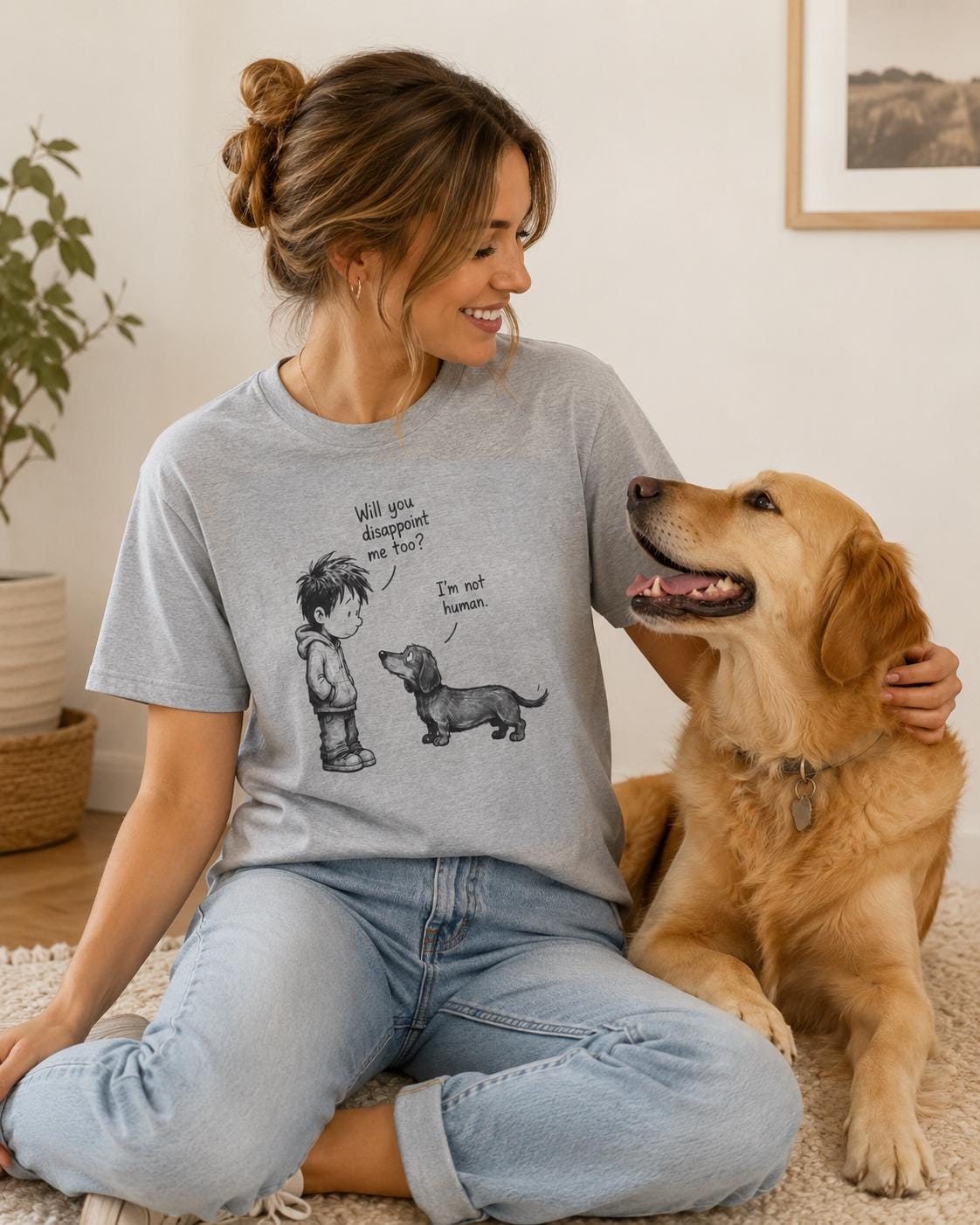 Frau im grauen Unisex-Shirt sitzt mit Labrador-Hund auf dem Boden, zeigt das Motiv