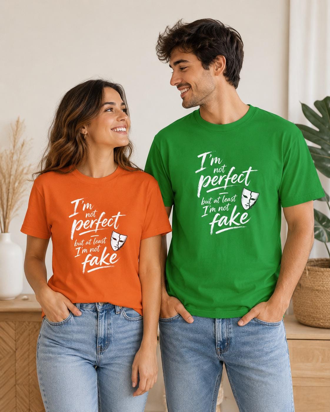 Paar mit orangenem und grünem T-Shirt mit weißer Statement-Botschaft lachen zusammen