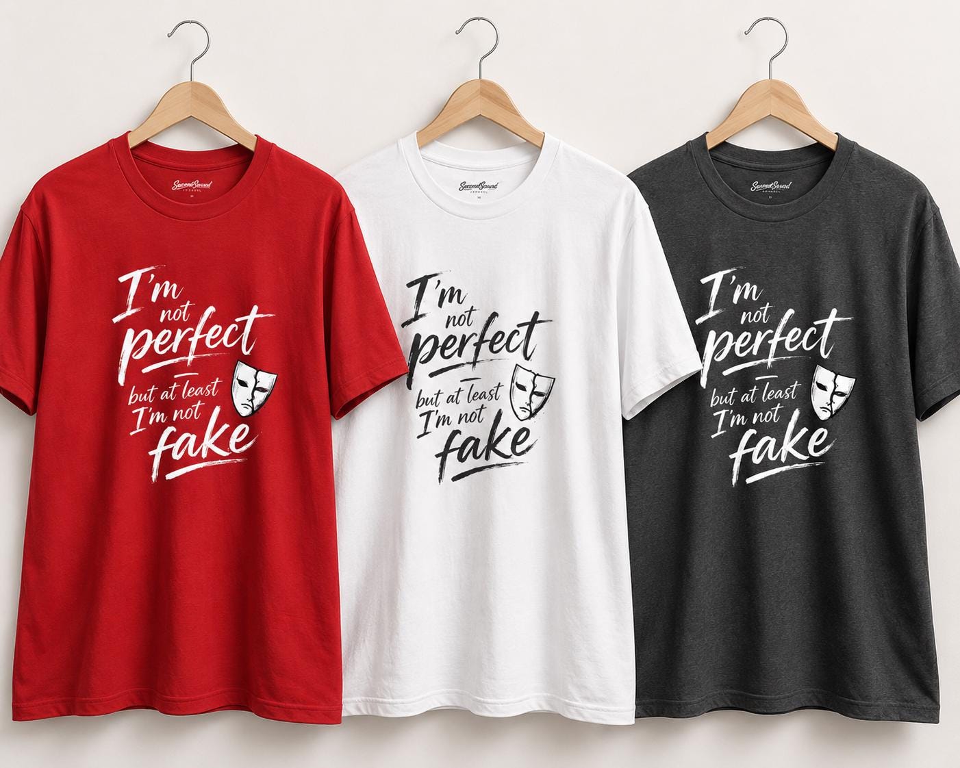 Drei T-Shirts in rot, weiß und schwarz auf Kleiderbügeln mit Statement-Aufdruck