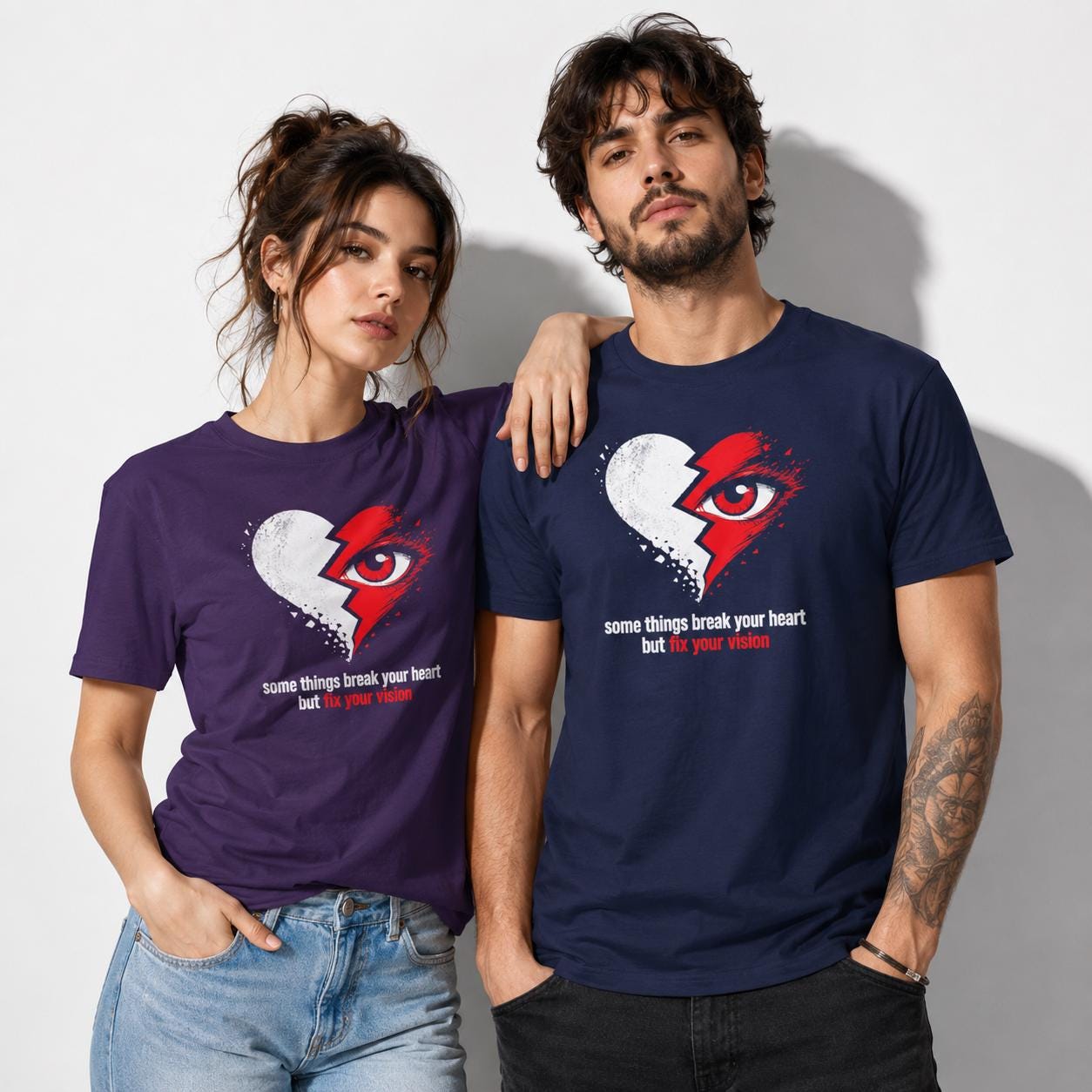 Paar trägt dunkelblaue und lila Shirts mit identischem Herz-und-Auge Design und motivierendem Text, lässig nebeneinander