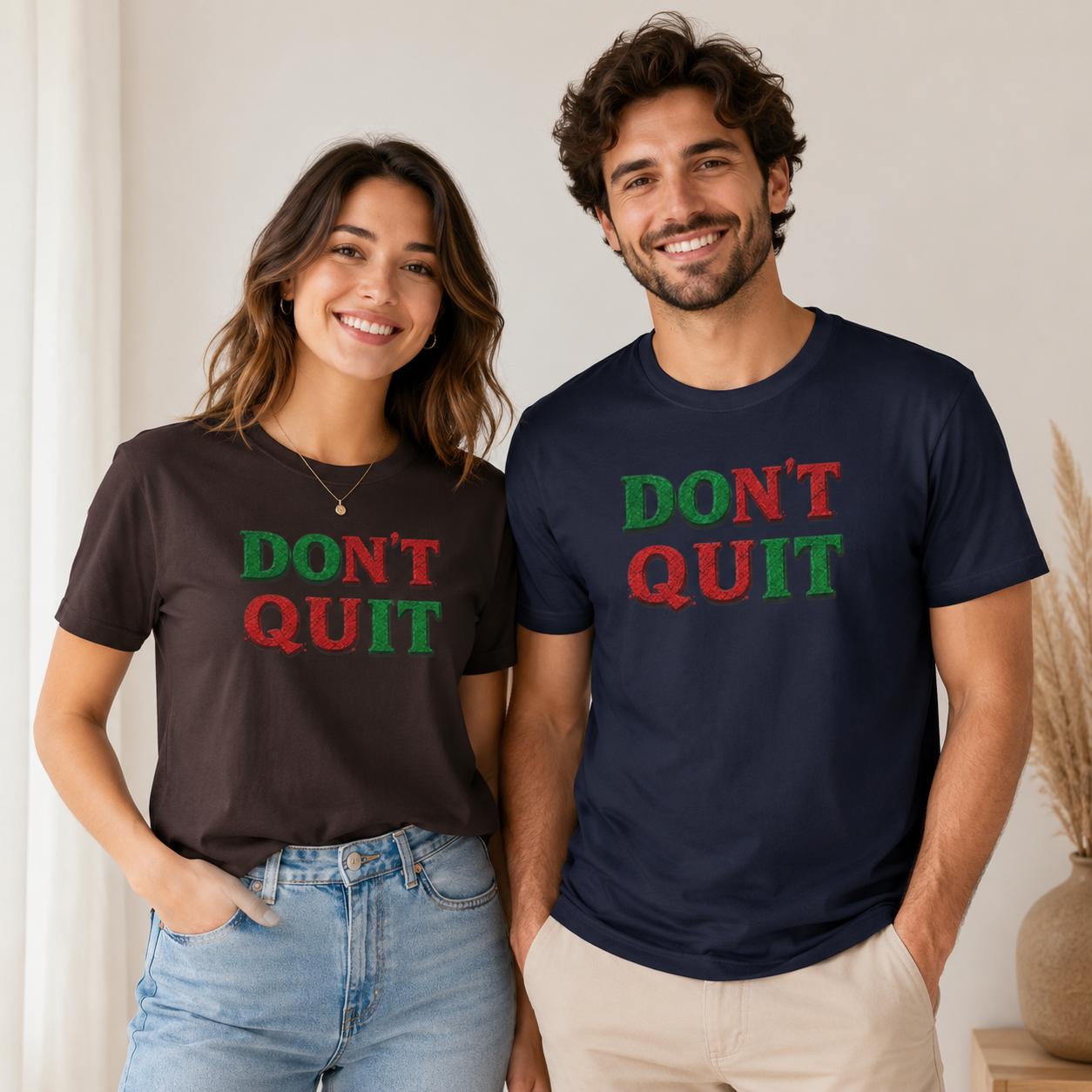 Frau und Mann tragen dunkelblaue T-Shirts mit ‚DON’T QUIT‘ Schriftzug in Grün und Rot