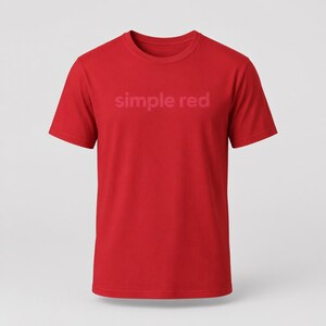 Könnte beinhalten: Ein einfarbiges rotes T-Shirt mit dem Schriftzug "simple red" in einem helleren Rotton auf der Brust. Das T-Shirt hat kurze Ärmel und einen Rundhalsausschnitt. Der Hintergrund ist weiß.