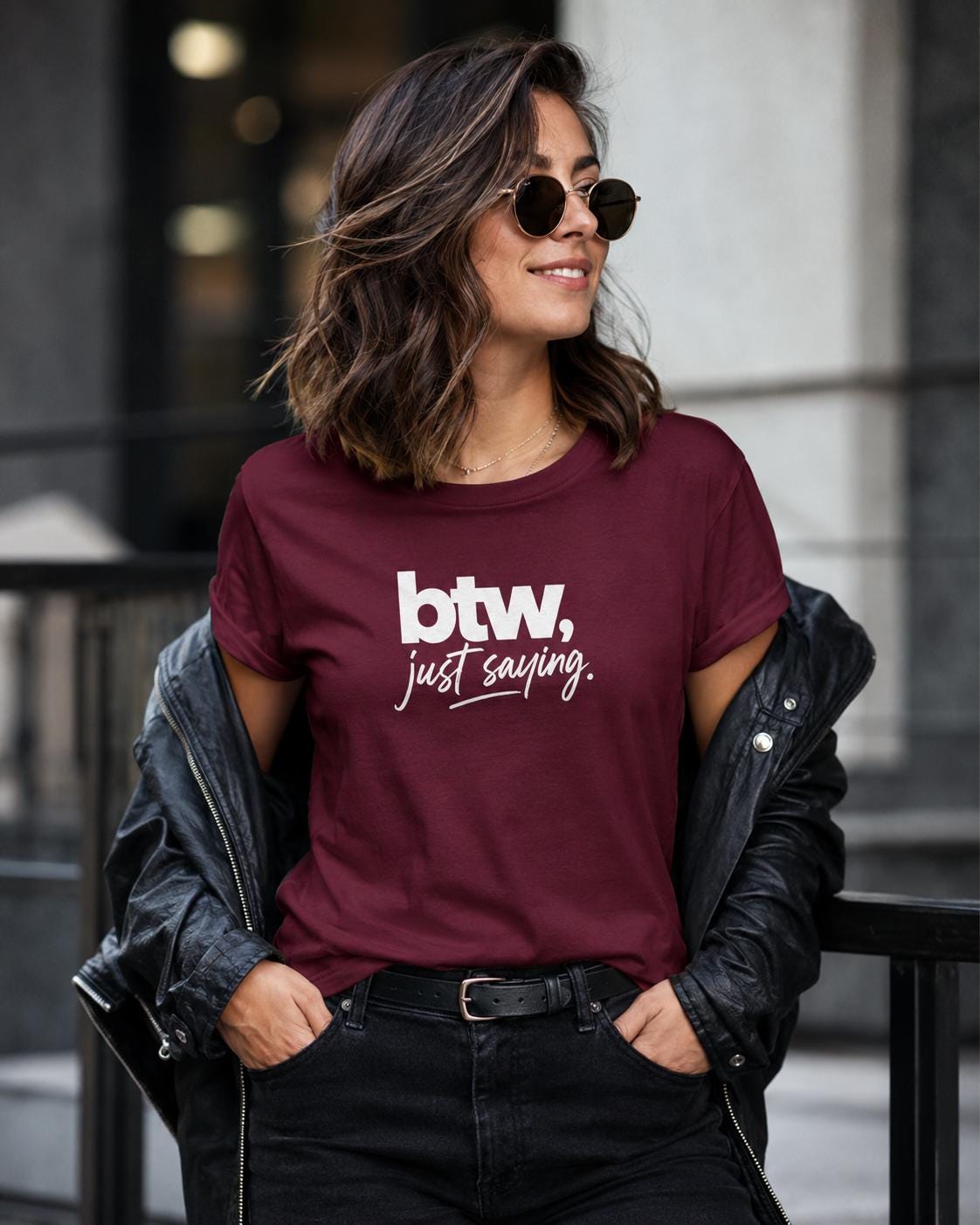 Frau trägt dunkelrotes T-Shirt mit weißem 'btw, just saying.' Schriftzug, schwarze Jacke und schwarze Hose