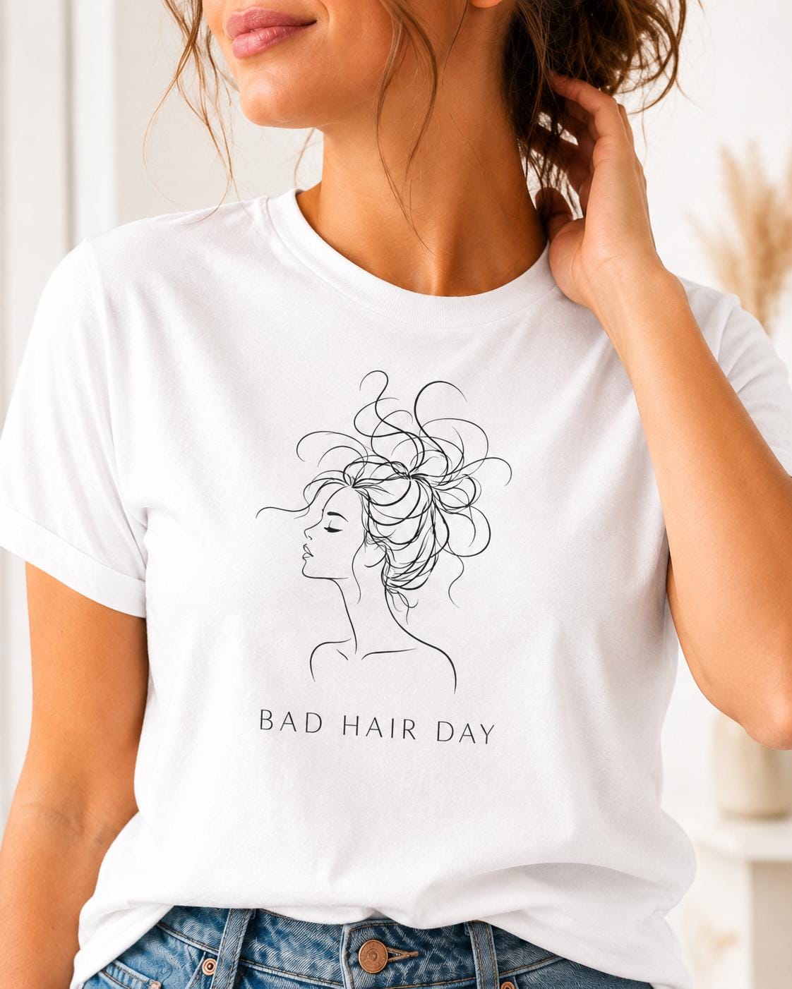 Damen T-Shirt in Weiß mit minimalistischer Line Art Illustration einer Frau mit chaotischer Hochsteckfrisur und Schriftzug Bad Hair Day