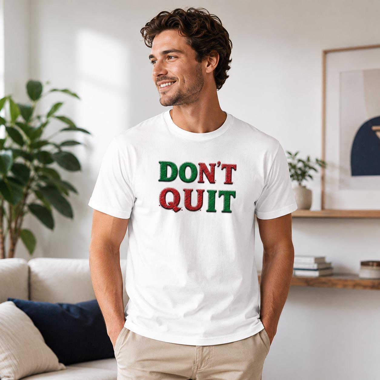 Weißes T-Shirt mit ‚DON’T QUIT‘ Schriftzug in Rot und Grün auf Brust getragen von lächelndem Mann