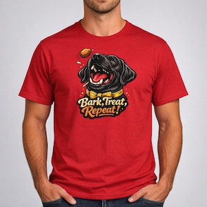 Könnte beinhalten: Rotes T-Shirt mit einer Cartoon-Illustration eines schwarzen Hundes mit offenem Maul, herausgestreckter Zunge und gelbem Halsband. Der Text "Bark, Treat, Repeat!" befindet sich unter dem Hund. Ein kleines, rundes Objekt befindet sich über dem Kopf des Hundes.