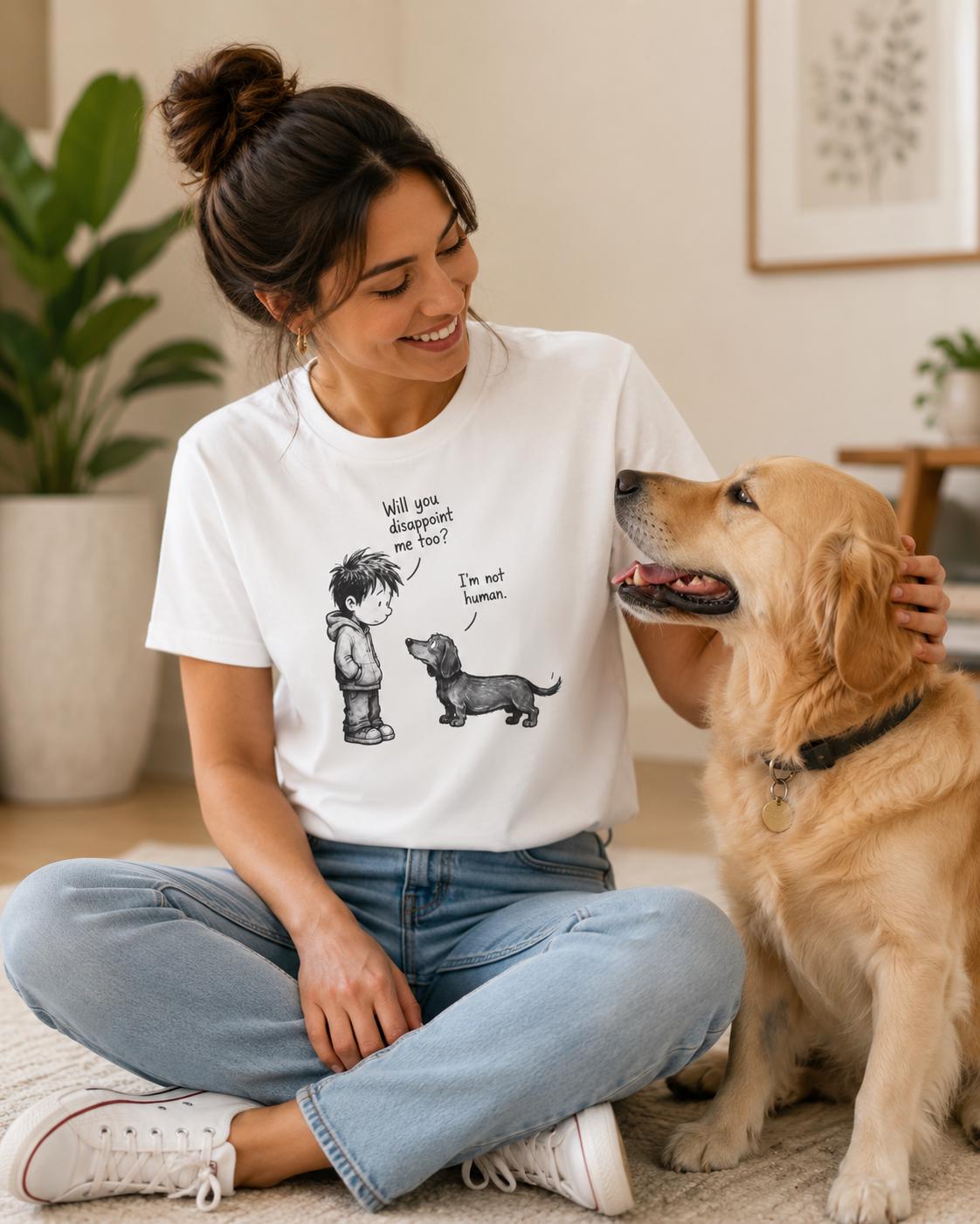 Frau trägt weißes T-Shirt mit Dackel-Illustration, schaut lächelnd zu einem sitzenden Hund