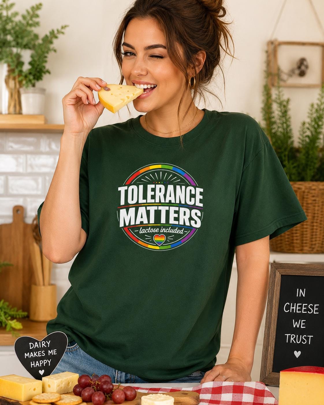 Frau isst Käse und trägt dunkelgrünes 'Tolerance Matters' T-Shirt mit farbigem Pride-Design