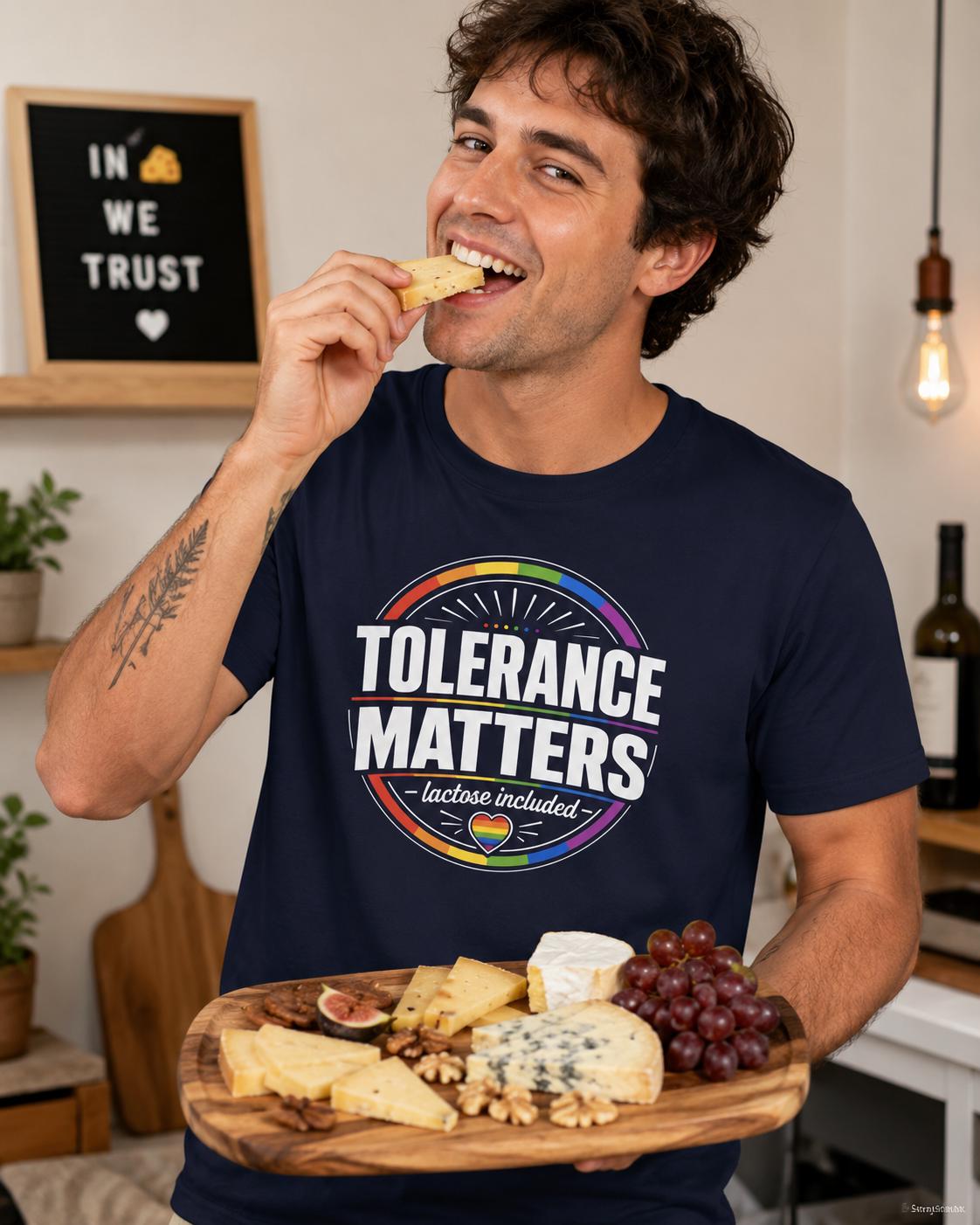 Mann trägt dunkelblaues Tolerance Matters T-Shirt und isst Käse mit einem Lächeln