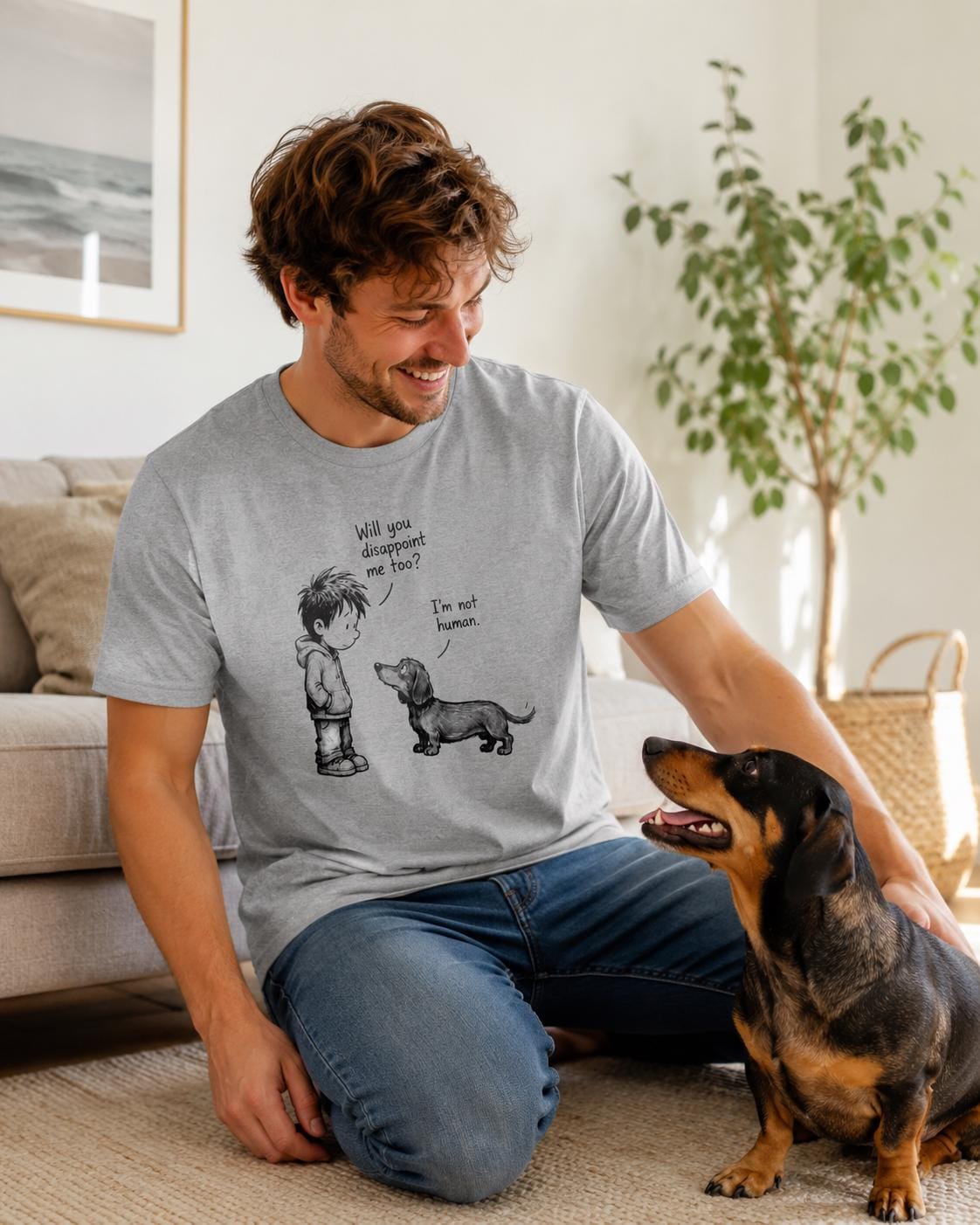 Mann trägt graues Dog Lover T-Shirt mit Dackel-Motiv, sitzt neben einem braunen Hund