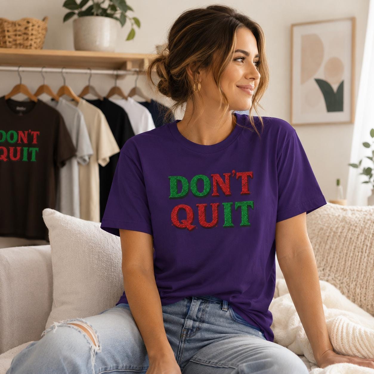 Frau sitzt auf Sofa und trägt lila T-Shirt mit ‚DON’T QUIT‘ Schriftzug in Rot und Grün