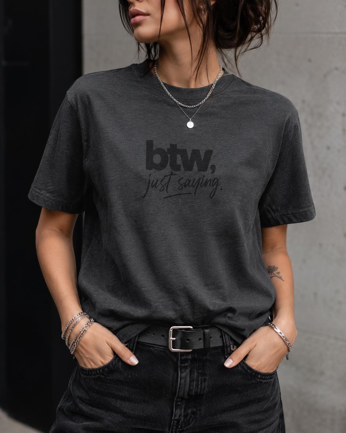 Person trägt schwarzes T-Shirt mit schwarzem 'btw, just saying.' Schriftzug in dezentem Typo-Design
