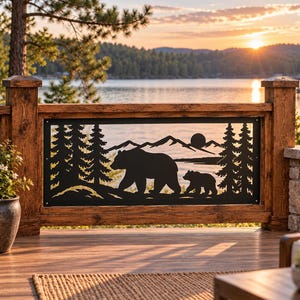 May include: A rectangular black metal decorative panel featuring a laser-cut silhouette of a large bear and a cub walking through a forest with pine trees and mountains in the background, mounted between two vertical wooden deck posts.