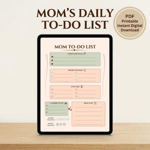 Può includere: Un pianificatore digitale su un tablet con il testo "MOM'S DAILY TO-DO LIST". Il pianificatore ha sezioni per "Today's Main Focus", "Around the House", "Little Ones", "A Moment for Me" e "Brain Dump". Include anche un tracker dell'acqua e dell'umore.