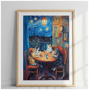 May include: A framed art print depicting four cats sitting around a round wooden table eating pizza. The scene is set on a balcony at night with a starry sky background. The wall features several small framed portraits and a round wall clock.