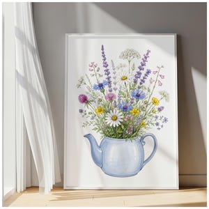 May include: A framed wall art print featuring a watercolour illustration of a light blue teapot filled with a vibrant bouquet of wildflowers, including white daisies, purple lavender, blue cornflowers, and small yellow blossoms.