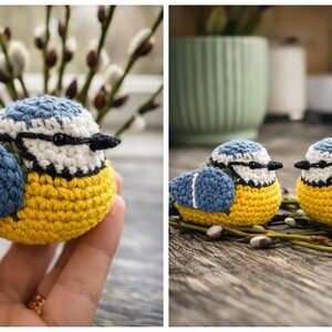 May include: Two crocheted blue tit birds featuring a rounded shape, bright yellow bellies, blue wings with white accents, white faces with black eye patches, and small black beaks. The birds are crafted with detailed yarn stitching.