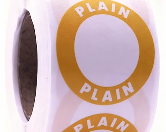 Puede incluir: Un rollo de etiquetas adhesivas circulares con un borde amarillo mostaza y la palabra PLAIN impresa en letras mayúsculas blancas. Las etiquetas están dispuestas en una secuencia continua sobre un papel soporte blanco, mostrando un diseño circular.