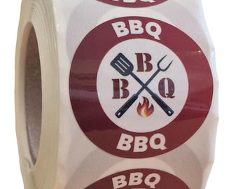 Puede incluir: Un rollo de etiquetas adhesivas circulares con un borde rojo oscuro y un centro blanco. El diseño incluye el texto BBQ en la parte superior e inferior, con un gráfico de una espátula y un tenedor cruzados, las letras B y Q y una llama.