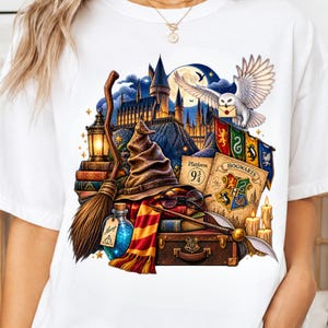 Może przedstawiać: Biały t-shirt z kolorowym nadrukiem graficznym przedstawiającym szkołę magii, tiarę przydziału, pasiasty szalik, miotłę, sowę śnieżną z listem, kufer, książki, okulary oraz butelkę z eliksirem z etykietą z napisem Always.