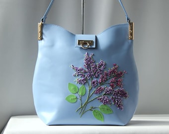 Handgemaakte blauwe leren tas met schouderriem en draaisluiting, grote damestas met paarse geborduurde lila bloem