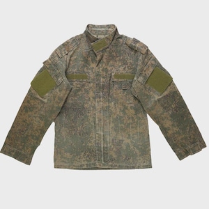 May include: A camouflage jacket in shades of green, brown, and tan. The jacket features a button-up front, a collar, and multiple pockets. Olive green patches are on the sleeves. The jacket is designed for outdoor wear.