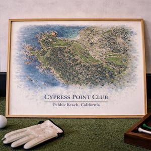 May include: A framed print of Cypress Point Club in Pebble Beach, California, with a golf ball, glove, and accessories on a green surface. The print features a watercolor-style map of the golf course. The text "CYPRESS POINT CLUB" is visible.