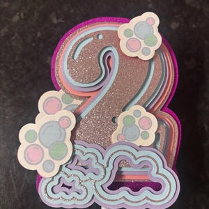 Op de afbeelding: Een set van drie keramische mokken met een gespikkelde, matte afwerking. De mokken zijn in crème, lichtgrijs en donkergrijs. Elke mok heeft een eenvoudig, minimalistisch ontwerp en een afgeronde handgreep.