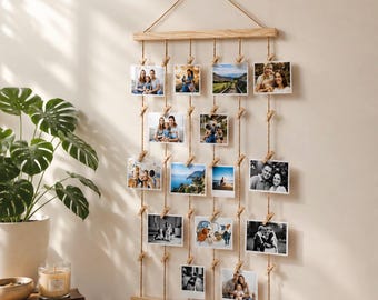 Könnte beinhalten: Ein Wand-Fotodisplay mit zwei horizontalen, hellen Holzleisten, die durch fünf vertikale Juteseile verbunden sind. Kleine Holzklammern sind an den Seilen befestigt, um vierzehn rechteckige Fotografien in verschiedenen Ausrichtungen zu halten.