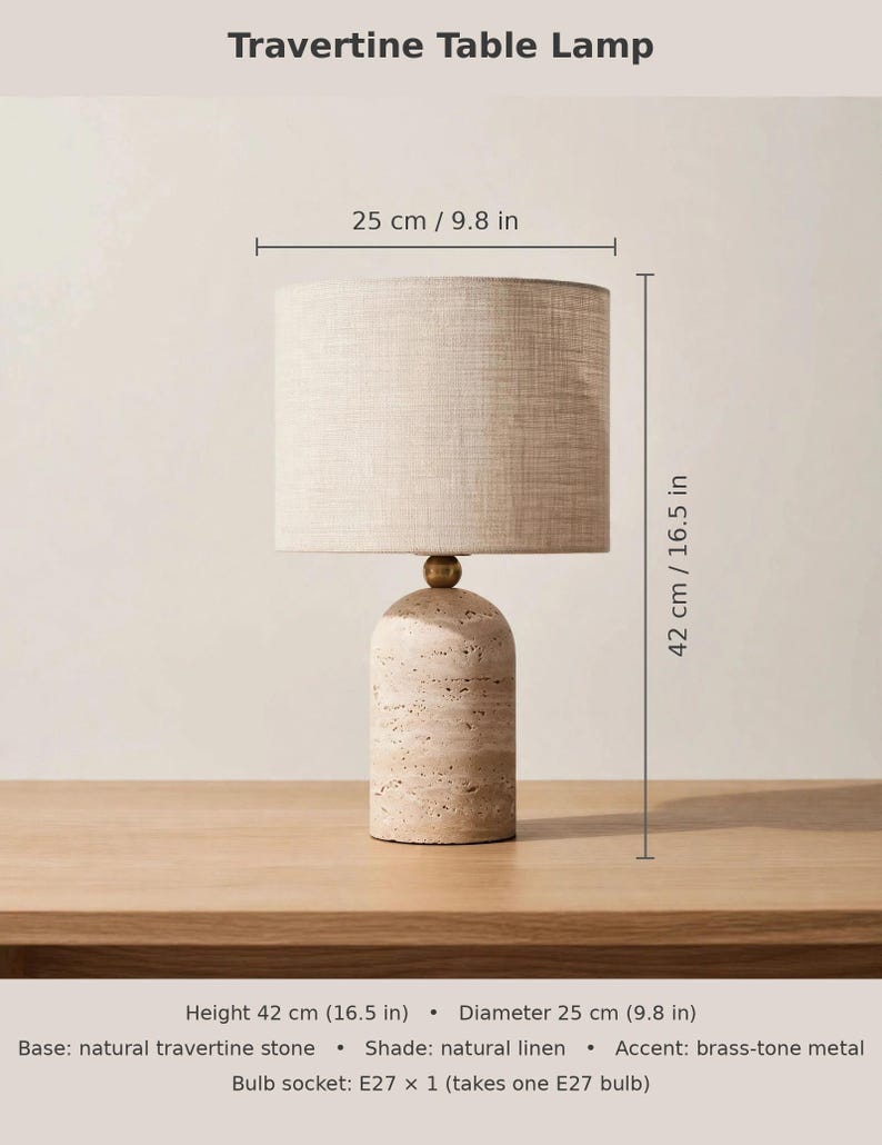 Pu&ograve; includere: Una lampada da tavolo in travertino con base cilindrica in pietra di travertino naturale, un dettaglio in metallo color ottone e un paralume a tamburo in lino naturale. La lampada misura 42 cm di altezza e 25 cm di diametro, con attacco E27.