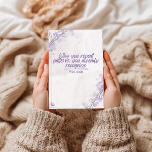 May include: A rectangular mini guide book with a white cover featuring purple floral accents in the corners and the text Why you repeat patterns you already recognize Mini Guide printed in purple. A small purple moon and star logo is at the bottom.