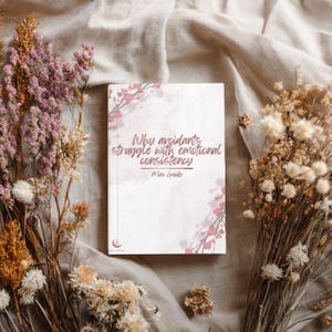 May include: A rectangular book with a white cover featuring a soft pink watercolour floral design and the text Why avoidants struggle with emotional consistency Mini Guide. A small crescent moon and star logo is printed at the bottom left corner.