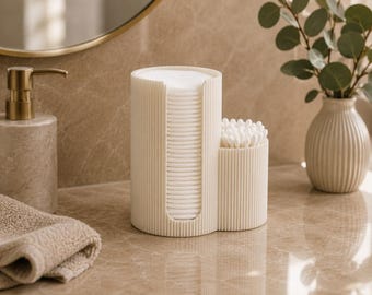 May include: A cream-coloured bathroom organiser with a ribbed texture, featuring a tall cylindrical section for holding a stack of round white cotton pads and a shorter adjacent cylindrical section for storing a cluster of white cotton swabs.