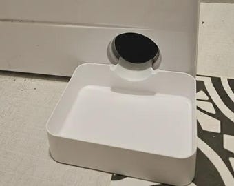 May include: A white plastic pet water dispenser featuring a rectangular basin and a circular opening at the back. The unit has a smooth, minimalist design with a curved spout that directs water into the shallow tray for easy access.