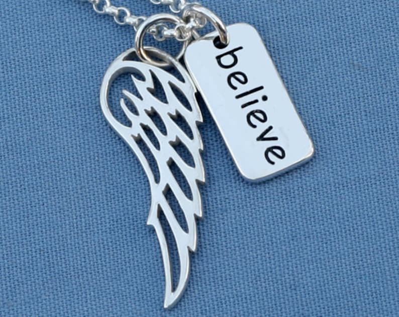 May include: Silver necklace with a delicate angel wing charm and a tag that says "believe".