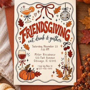 May include: A rectangular Friendsgiving invitation card featuring a cream background with a wavy black border. Illustrations include a cocktail, disco ball, wine glass, pumpkin, cherries, and candles. Text reads: Friendsgiving, eat, drink & gather, Saturday, November 23, 7:00 PM, Miller Residence, 123 Fall Avenue, Chicago, IL 12345, rsvp by Nov 10, 123-456-7899.