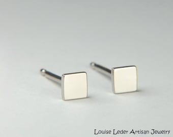 May include: A pair of silver square stud earrings. The earrings are small and simple, and they would make a great everyday accessory.