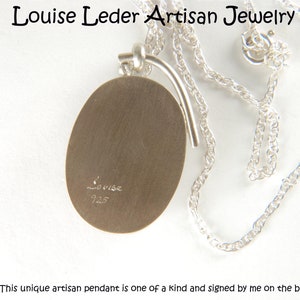 May include: A silver oval pendant necklace with a sterling silver chain. The pendant is signed "Louise 925" on the back. This unique artisan pendant is one of a kind and signed by me on the back.