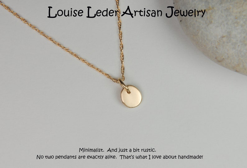 May include: A gold-colored necklace with a small, round pendant. The necklace is displayed on a light background. The text "Louise Leder Artisan Jewelry" is at the top. The text "Minimalist. And just a bit rustic. No two pendants are exactly alike. That's what I love about handmade!" is at the bottom.