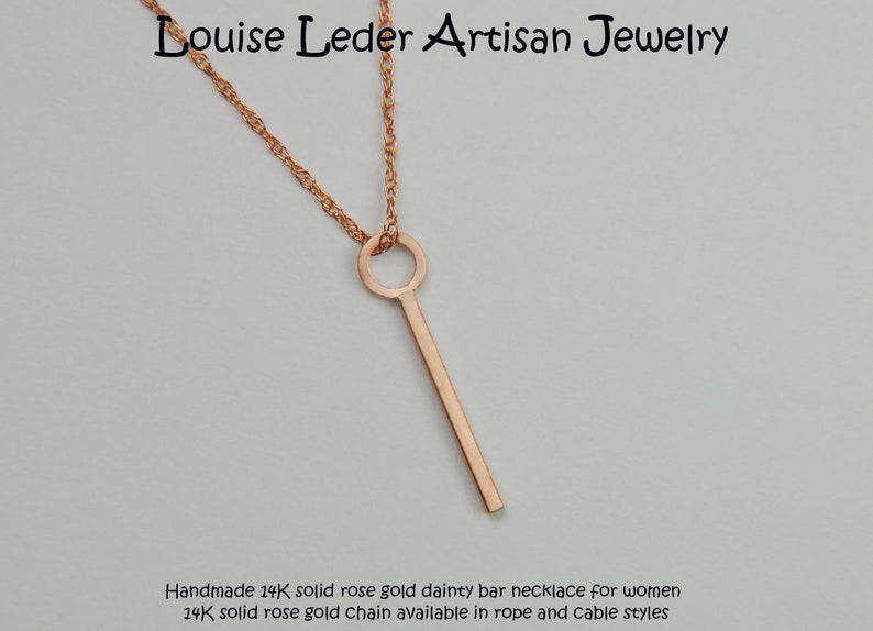 Puede incluir: Collar de barra de oro rosa con una cadena delicada. El colgante es una barra vertical delgada suspendida de un bucle circular. La cadena es de estilo cuerda trenzada. El texto "Louise Leder Artisan Jewelry" est&aacute; en la parte superior.