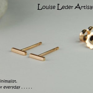 May include: A pair of gold bar stud earrings. The earrings are simple and minimalist.  "Simple. Minimalist. Perfect for everyday..."