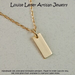 May include: A minimalist gold pendant necklace. The rectangular pendant hangs from a delicate gold chain. The jewelry is displayed on a light-colored surface. The text "Louise Leder Artisan Jewelry" is visible.