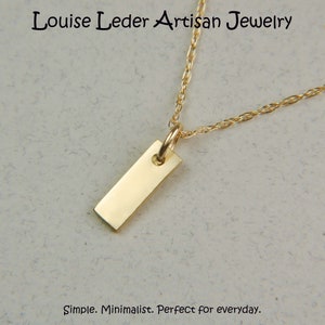 May include: A gold-coloured rectangular pendant necklace. The pendant hangs from a delicate chain. The text "Louise Leder Artisan Jewelry" is at the top of the image. The text "Simple. Minimalist. Perfect for everyday." is at the bottom.