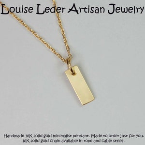 May include: A minimalist gold pendant necklace. The rectangular pendant hangs from a delicate gold chain. The text "Louise Leder Artisan Jewelry" is at the top. The necklace is handmade.