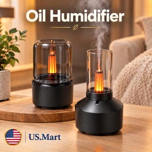 May include: Two black oil humidifiers with clear glass cylindrical covers and internal orange flame-effect lights. The right unit emits a visible stream of mist. The text Oil Humidifier and US.Mart are displayed on the image.